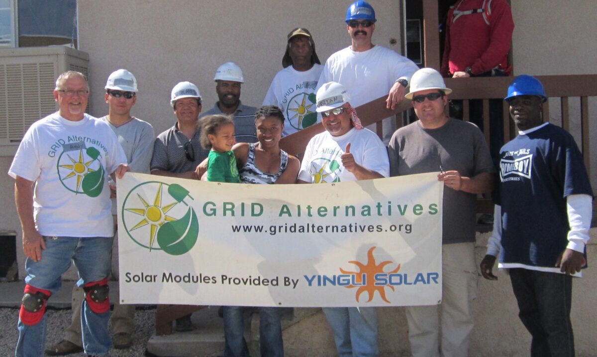 Group holding GRID Alternatives banner with solar modules provided by Yingli Solar