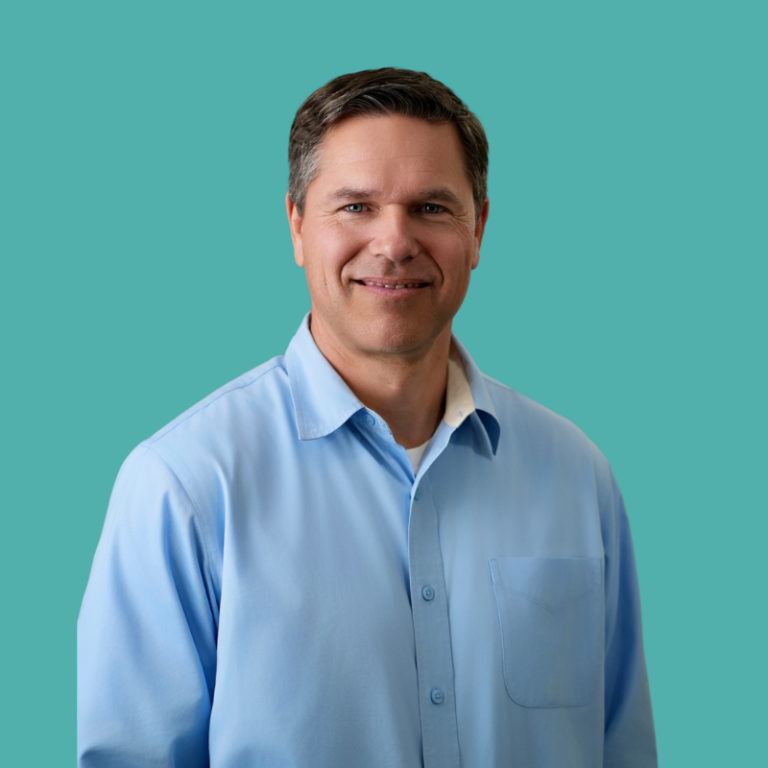 Tim Sears, a man with brown hair wearing a light blue button-up shirt, smiling against a turquoise background