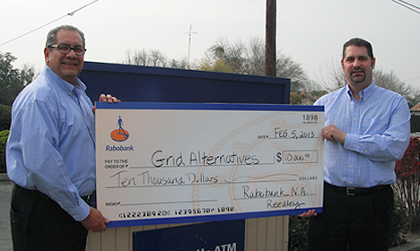 Two men in blue shirts holding oversized check for $10,000 to Grid Alternatives from Rabobank