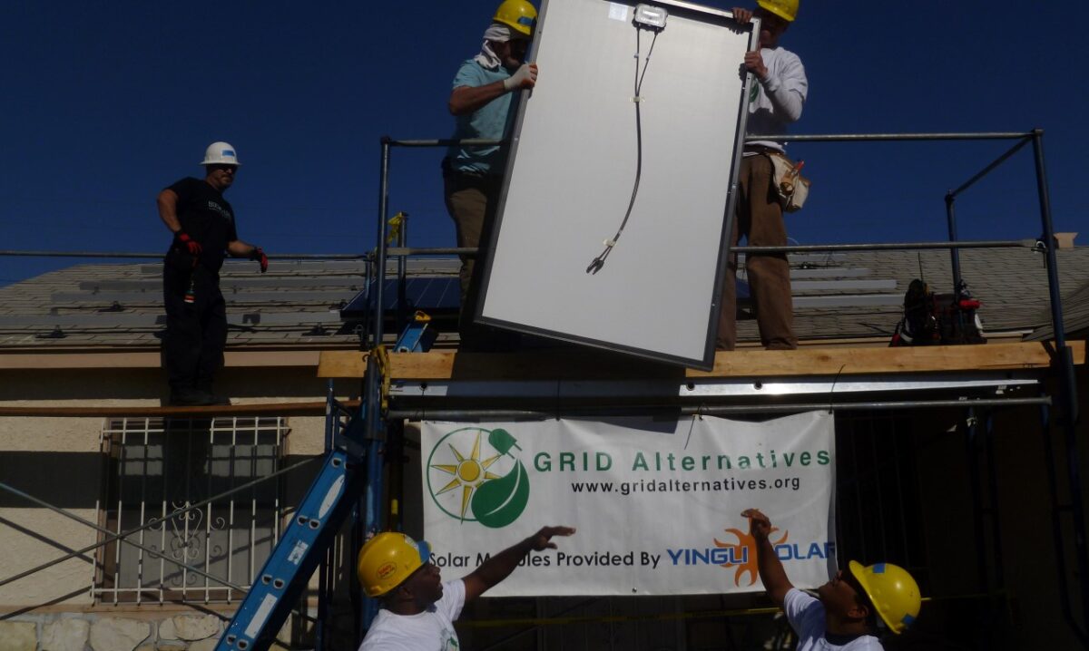 Workers installing solar panels on a rooftop for GRID Alternatives, an environmental organization promoting renewable energy