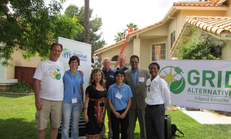 Group of people posing at 2013 Solarthon event with Habitat for Humanity and GRID Alternatives banners