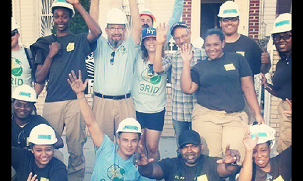 Group of people wearing hard hats and work vests celebrating with fists raised, #GRIDgoesEast