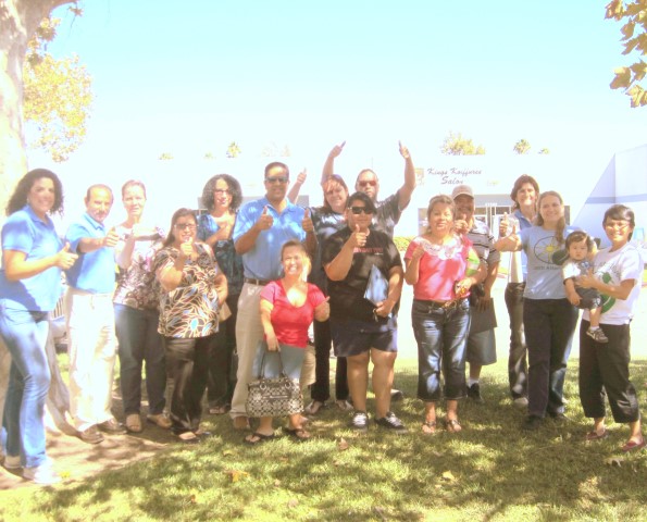 Group of diverse people celebrating outdoors at Solarthon event with arms raised in victory