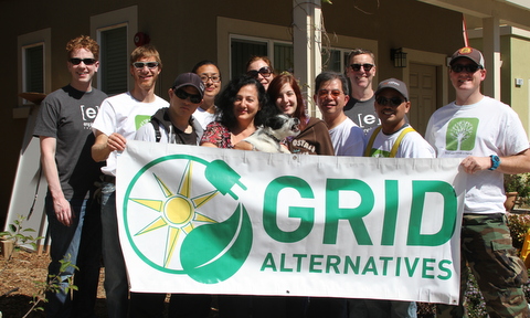 Group of volunteers holding GRID Alternatives banner at community event
