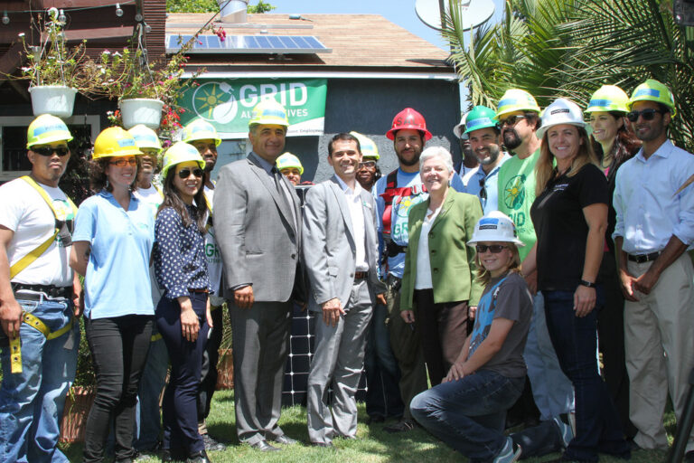 Group photo of EPA officials and workers wearing hard hats at Grid Alternatives facility in Long Beach