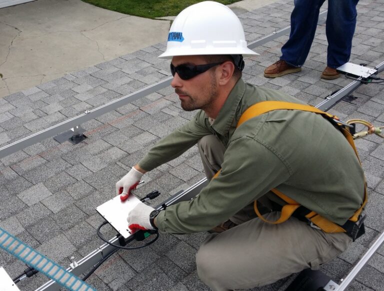 Worker in hard hat and safety gear performing roof inspection with clipboard and measuring tools