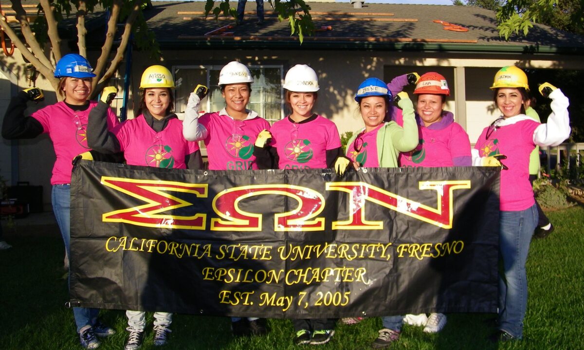 Eight women in hard hats and pink shirts hold banner for Sigma Omega Nu, California State University Fresno Epsilon Chapter, established May 7, 2005