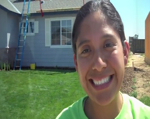 Floricel Martinez smiling at camera in front of house under construction