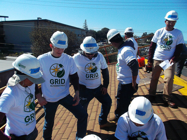 Group of GRID Alternatives workers in hard hats and matching shirts at a construction site training event