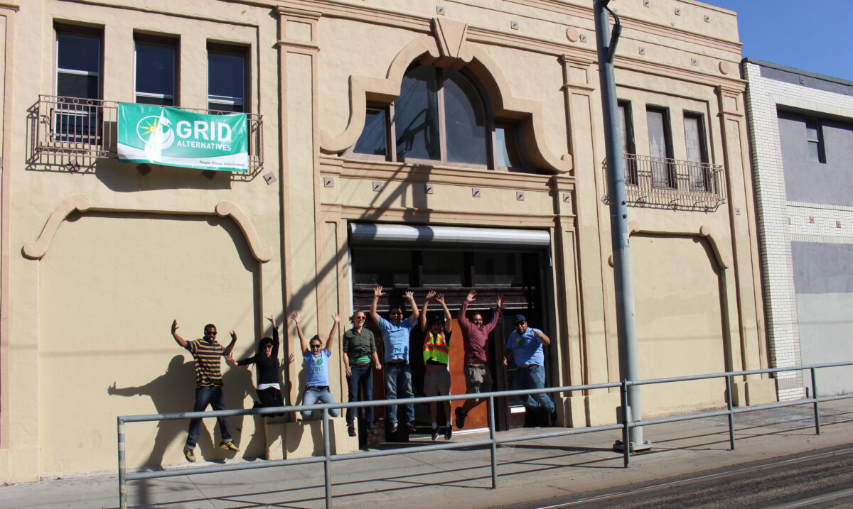 Group celebrating outside GRID Alternatives building entrance in Los Angeles