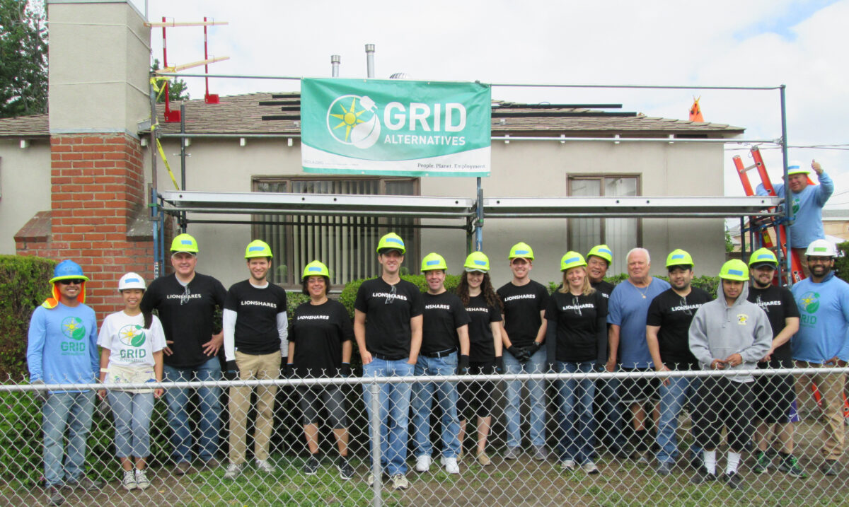 Lionsgate team in hard hats poses under GRID Alternatives banner at solar installation in Van Nuys