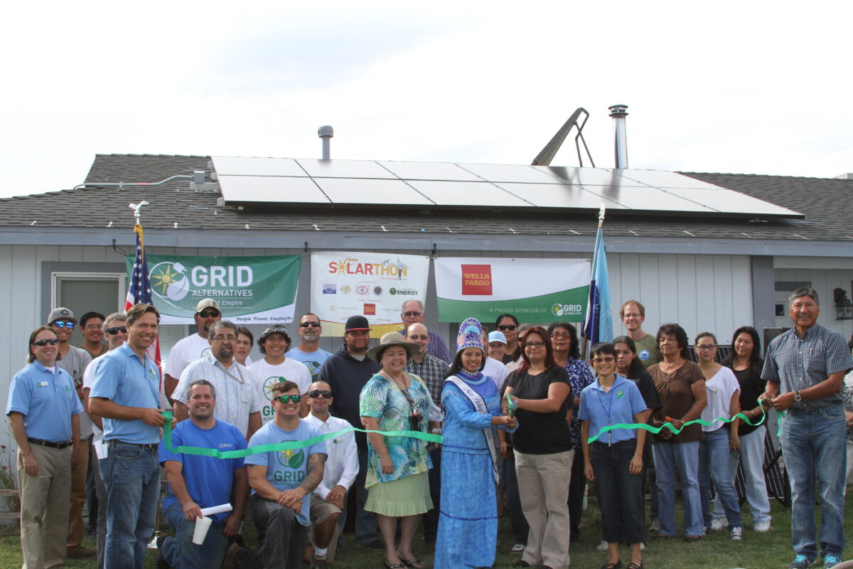 Community ribbon-cutting ceremony for solar panel installation on tribal building with GRID Alternatives and Wells Fargo sponsorship banners