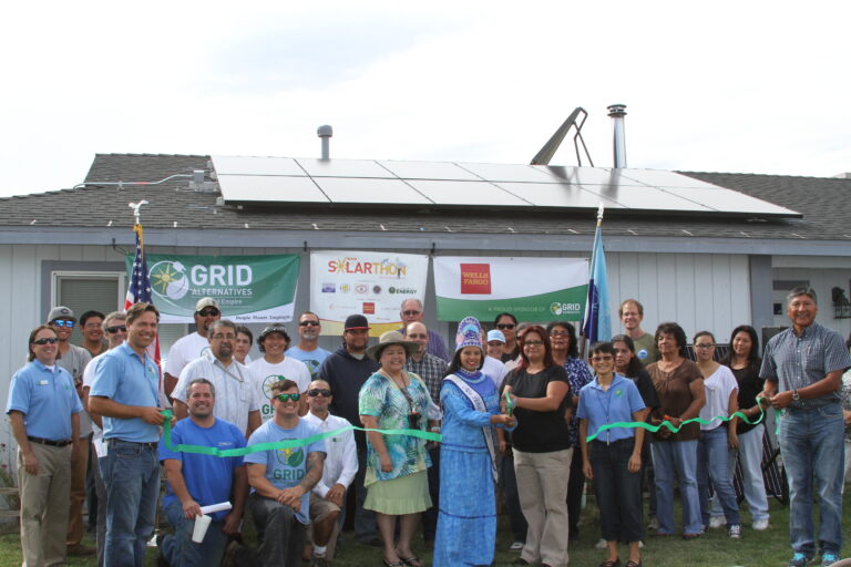 Community ribbon-cutting ceremony for solar panel installation on tribal building with GRID Alternatives and Wells Fargo sponsorship banners