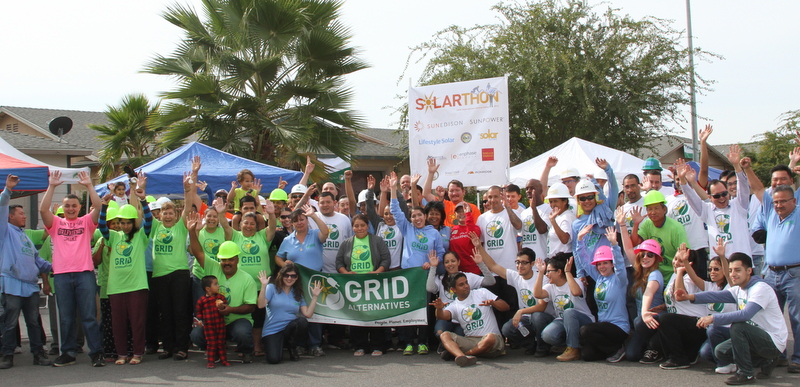 Large group wearing green GRID shirts at outdoor "Sklar-thon" charity event with banner and tents