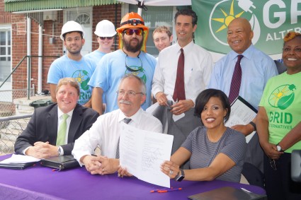 Group of officials and construction workers at solar energy initiative signing ceremony in Baltimore