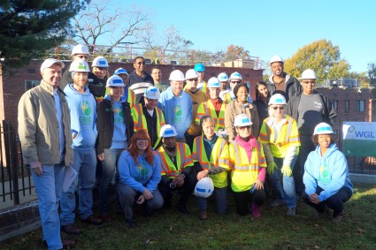 Group of construction workers and supervisors in hard hats and safety vests at a weatherization workday event