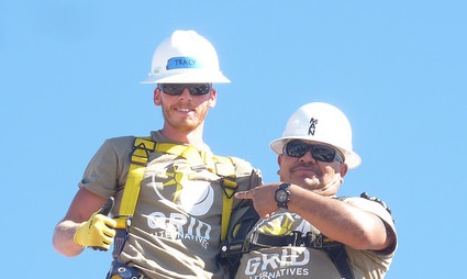 Two construction workers in hard hats and safety gear against blue sky, representing workforce opportunity