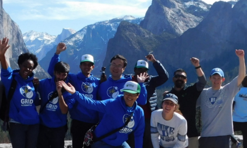 Duke Blue Devils team celebrates in front of snow-capped mountains during spring break service project