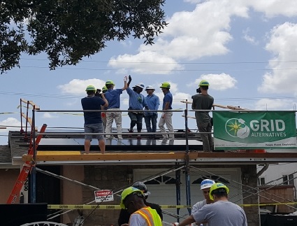 Construction workers in safety gear stand on scaffolding at a GRID partnership event with Southern California Honda Dealers on Earth Day