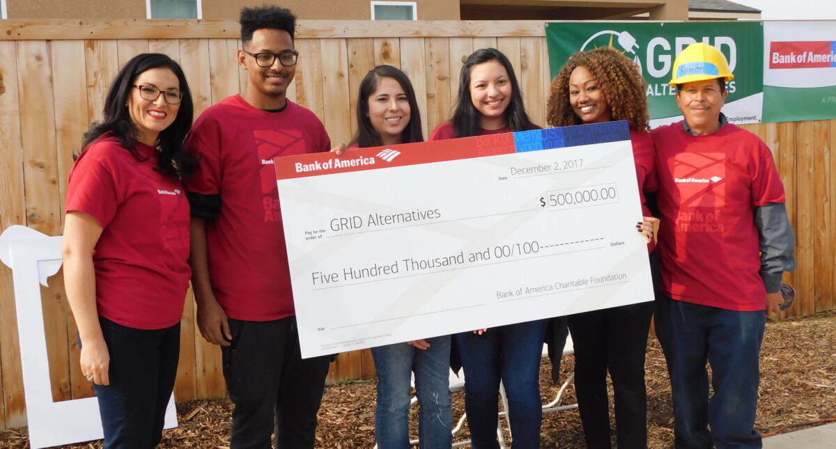 Six people in red shirts hold a $500,000 Bank of America check for GRID Alternatives, dated December 2, 2017