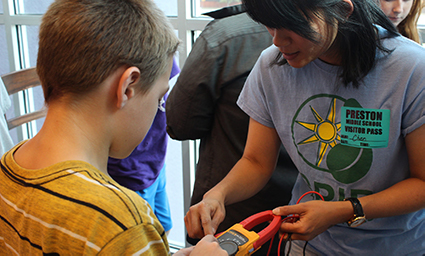 Women teaches boy about solar