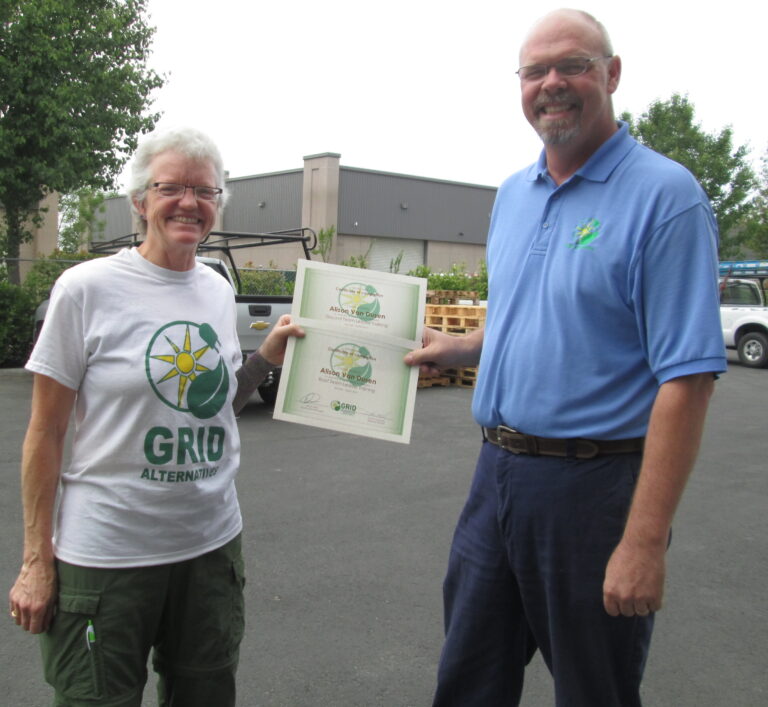Two people holding Allevi Vegan Garden award certificates outdoors