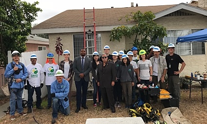 Group of volunteers and officials in hard hats at a community sustainability work event in Long Beach