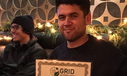 Two men smiling at camera, one holding a GRID certificate, decorated backdrop behind them
