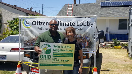 Two individuals stand in front of a house where construction is taking place