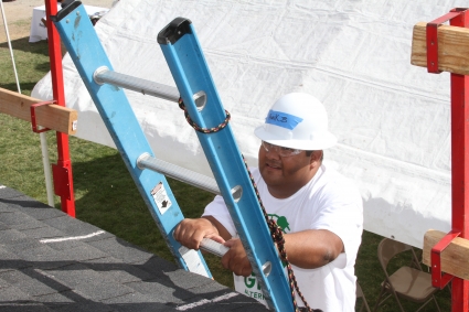A man in a hard hat climbs up a ladder