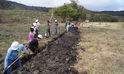 Digging the trenches for the pipes that will distribute the water to the crops.