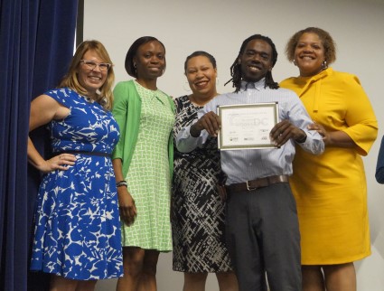 Trainee Daniel poses with the graduation speakers, Nicole Steele of GRID, Tarasa Lawrence of DOEE, Unique Morris-Hughes of DOES, and Deputy Mayor Courtney Snowden