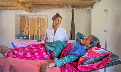 Healthcare worker examining patient on colorful bed in medical facility