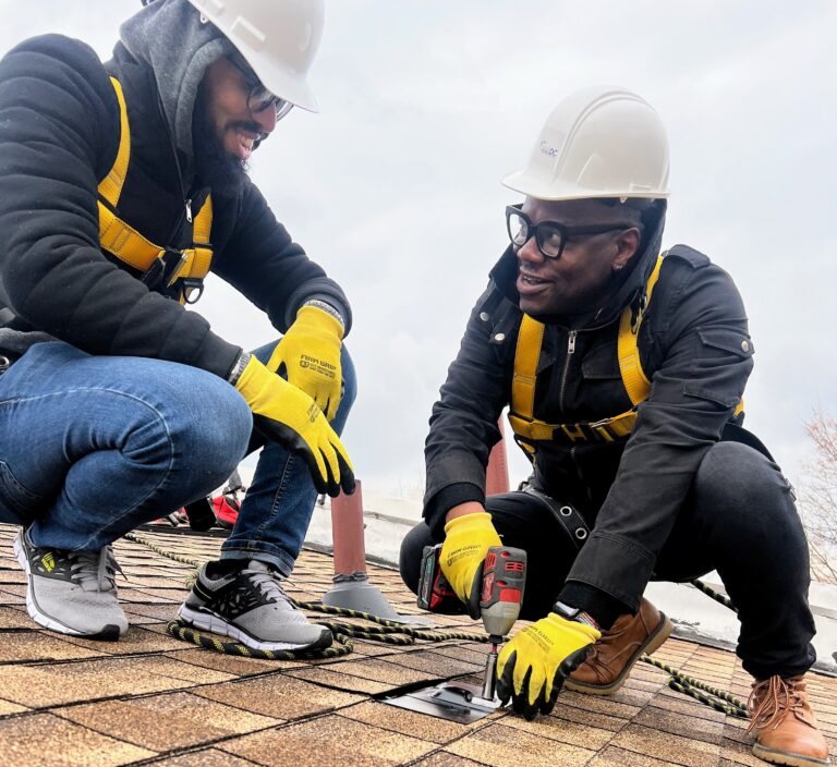GRID Mid-Atlantic Executive Director Elijah Perry (right) participates in a solar installaltion in December 2023.