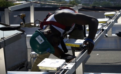 A Solar Works DC job trainee installs an inverter
