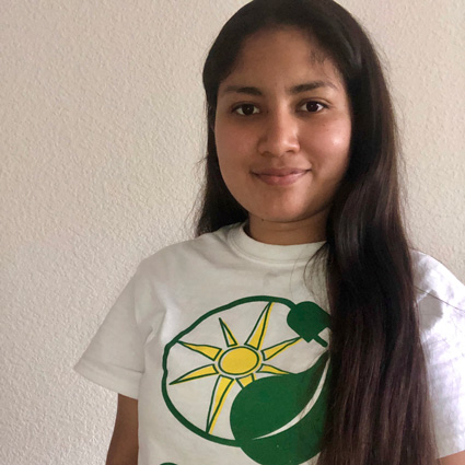 Girl wearing white t-shirt with green and yellow sun logo design
