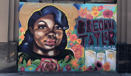 Breonna Taylor mural with portrait surrounded by colorful flowers and gold halo