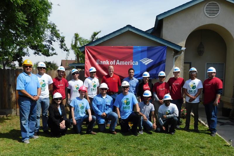 Bank of America and Fresno State volunteers in hard hats pose for group photo at community installation event in Reedley