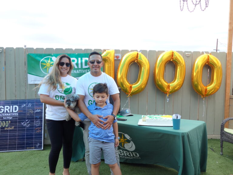 Family at GRID Alternatives event celebrating 1000 solar installations with gold balloons