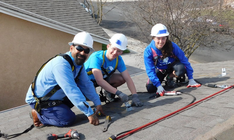 Jenna Poplausky and Samuel Corwin learning on the roof with Adrian Sanchez