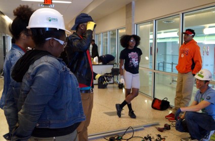 Dave Johnson leads a group of students in a mock solar installation