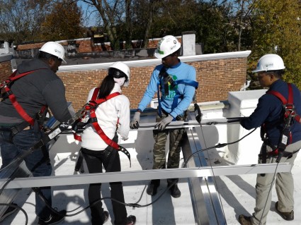 Dominic serving his community, teaching volunteers about solar