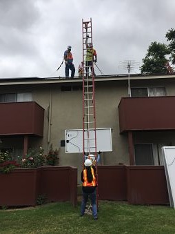 A father and daughter volunteering at an install coordinate the lift of a module