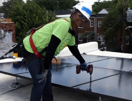 Homeowner Pamela joined volunteers on the roof to install her solar
