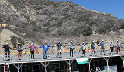 Group of people standing on a platform with a hillside background during an event