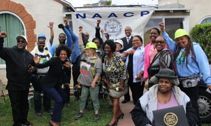 Group of people celebrating in front of NAACP banner outdoors
