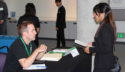 A job fair attendee speaks with an employer about opportunities during the Bay Area Summer Job Fair.