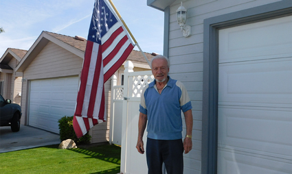 Man standing in front of house with American flag displayed on garage entrance