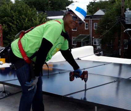 Our homeowner Pamela, installs the final solar panel on her roof