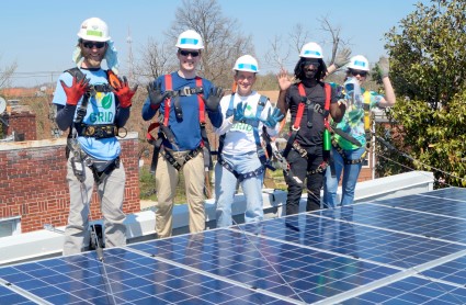 GRID staff and volunteers pose by a completed solar system